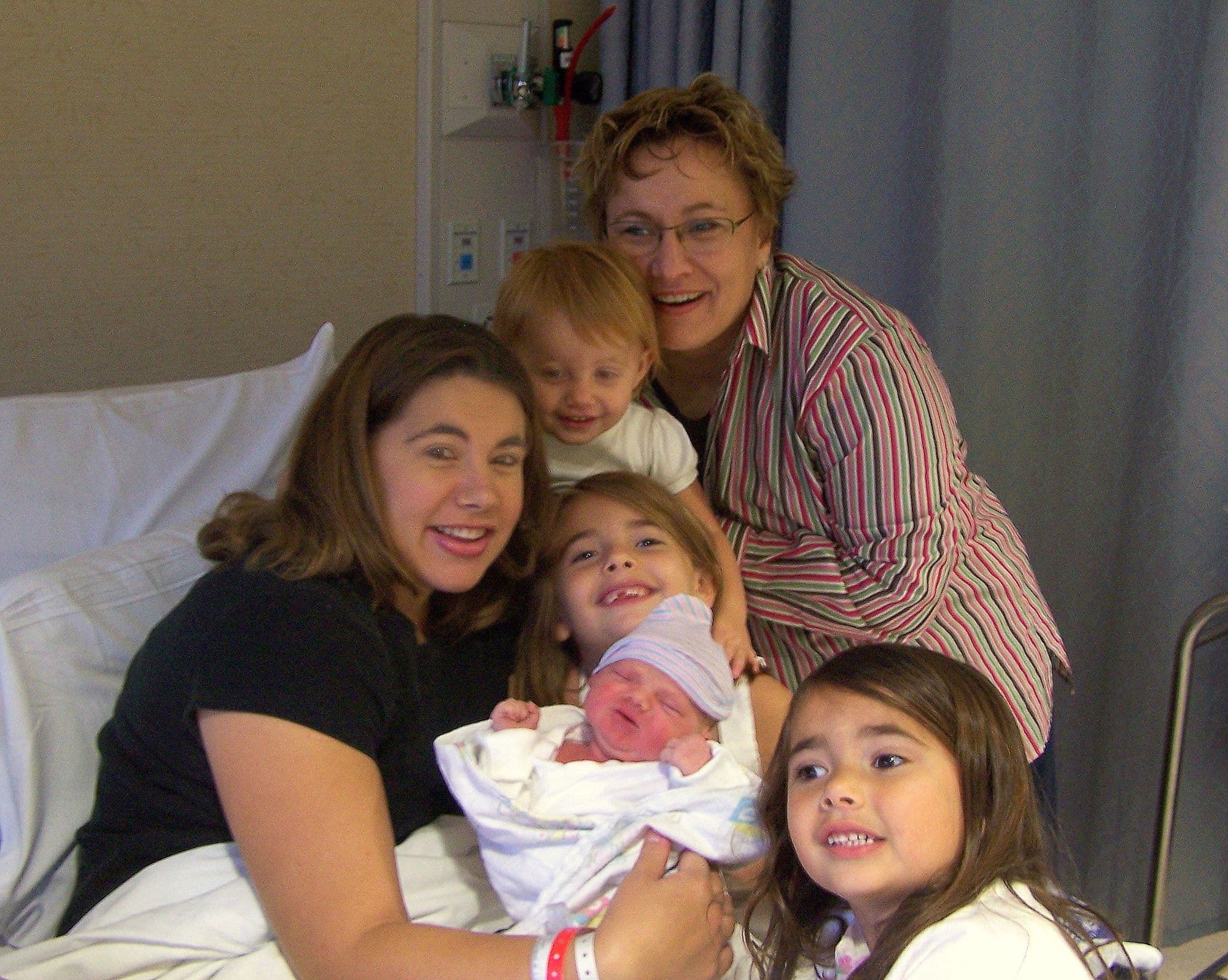 Family gathered around a newborn in the hospital