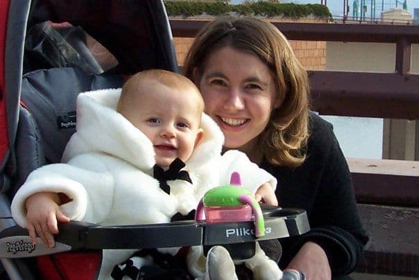 Woman holding baby in a stroller on a deck