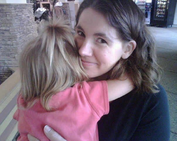 Woman and girl cheek to cheek indoors