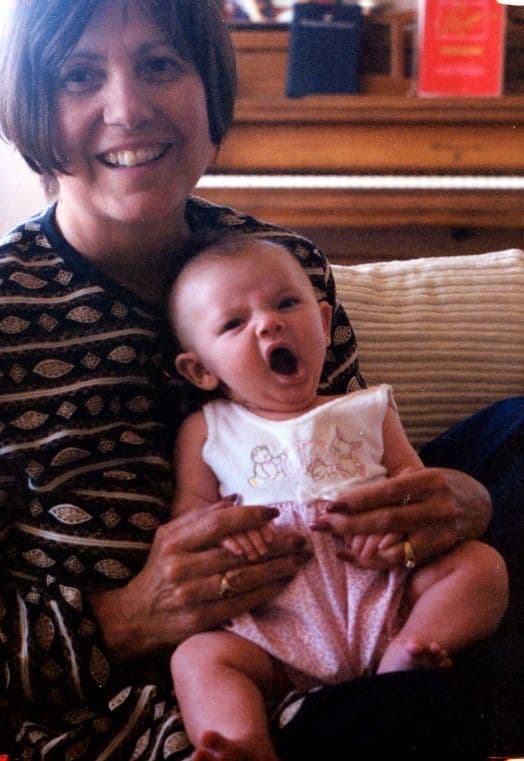 Older woman holding a baby indoors