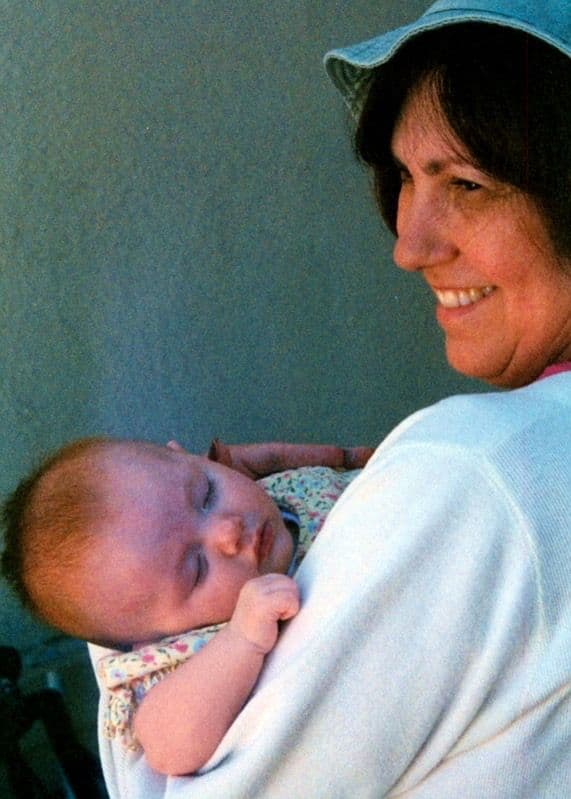 Woman holding an infant, older photo