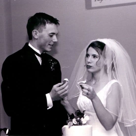 Black and white photo of groom feeding bride cake