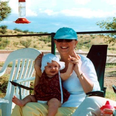 Woman in a sunhat holding a baby outdoors