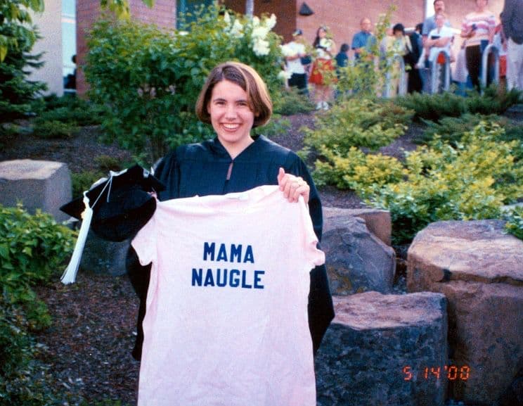 Woman in graduation gown holding a shirt