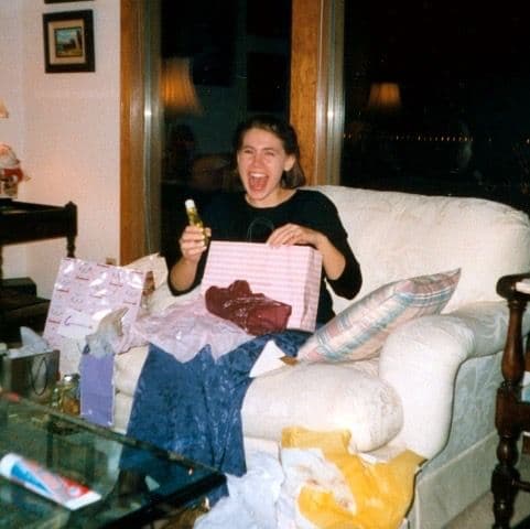 Woman opening gifts on a couch