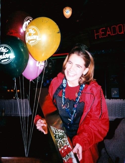 Woman holding balloons and a gift