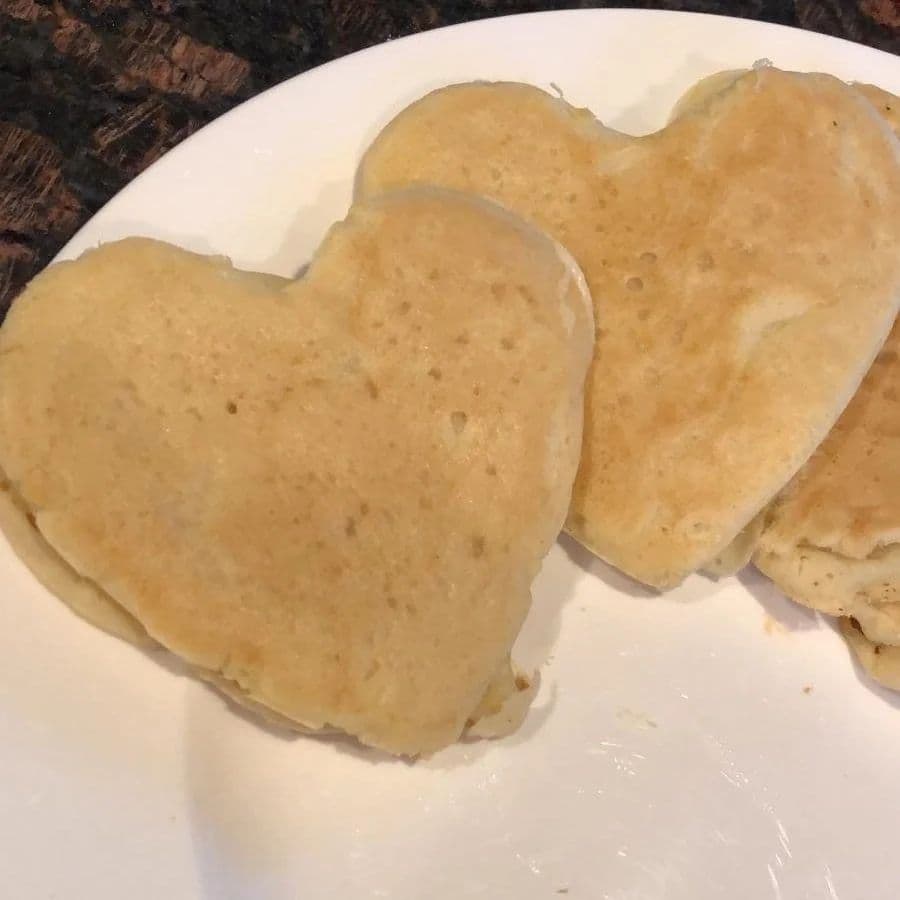 Two heart-shaped pancakes on a white plate