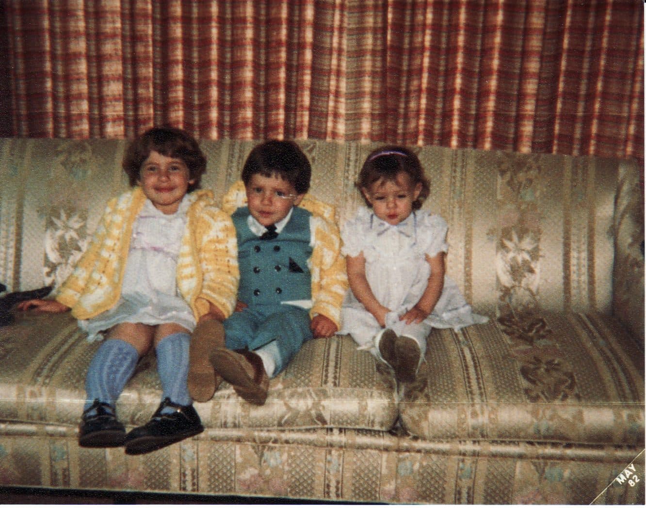 Three children dressed up on a couch