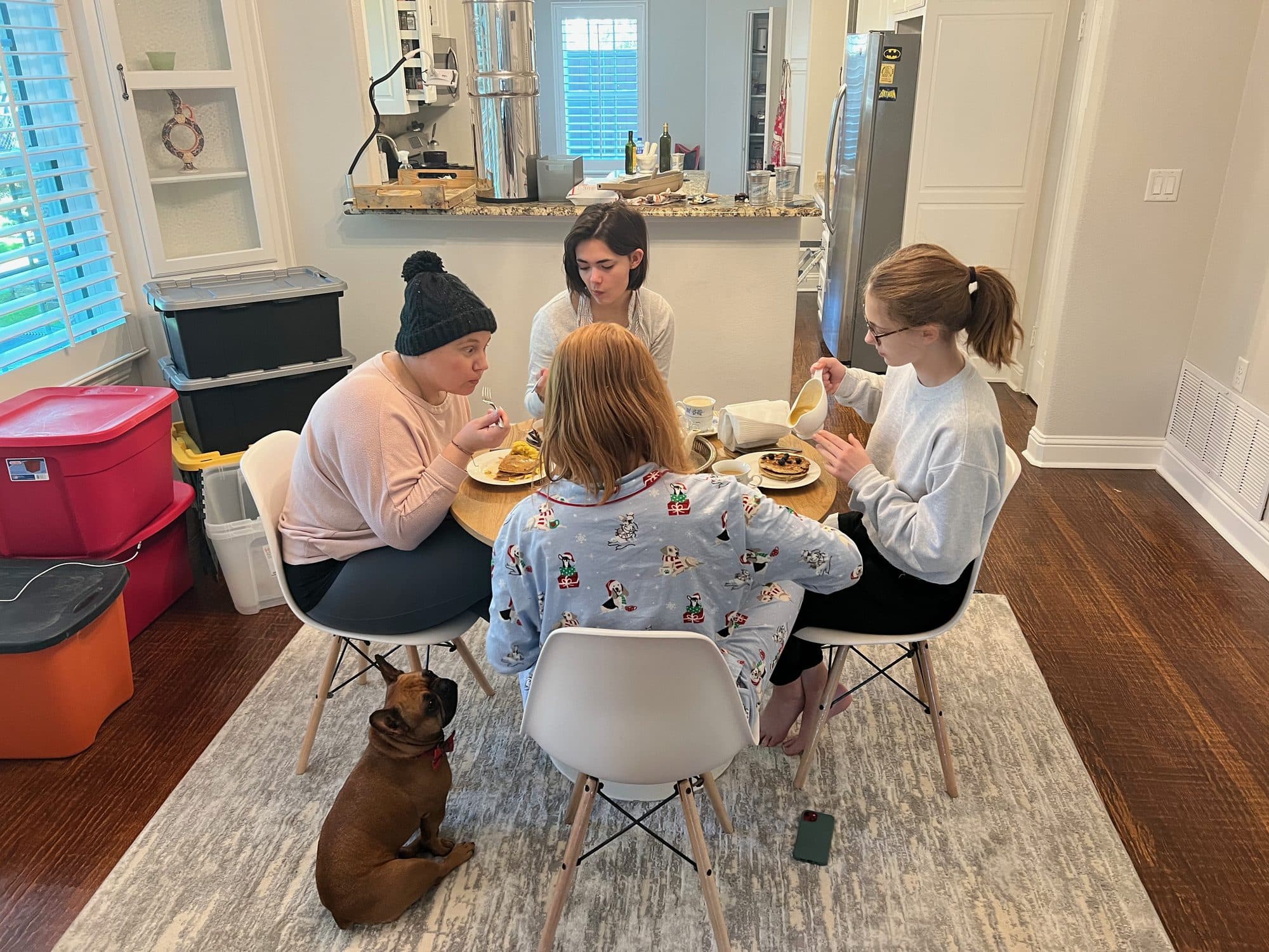 Family gathered at a kitchen table with a dog