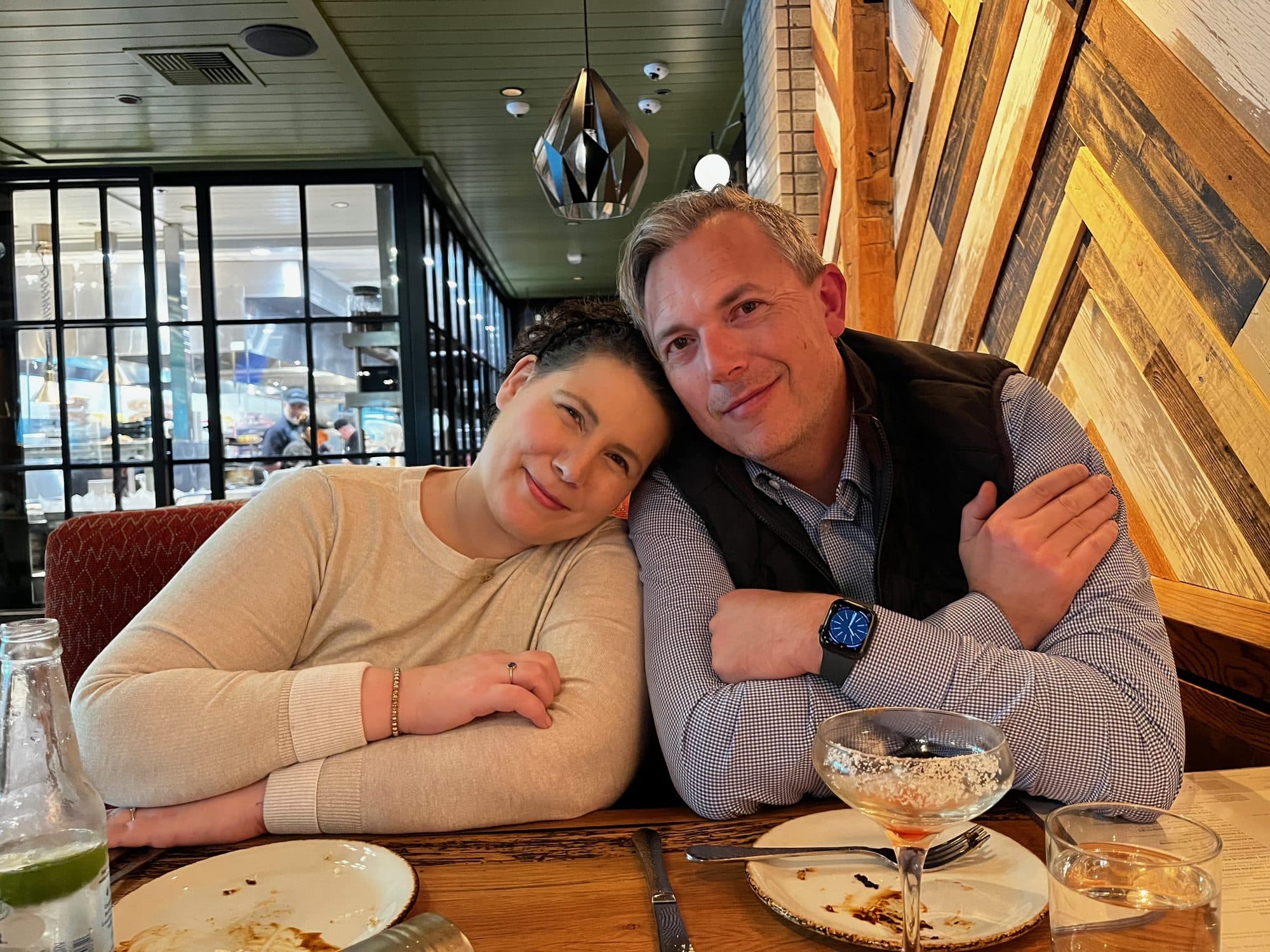 Couple leaning together at a restaurant table