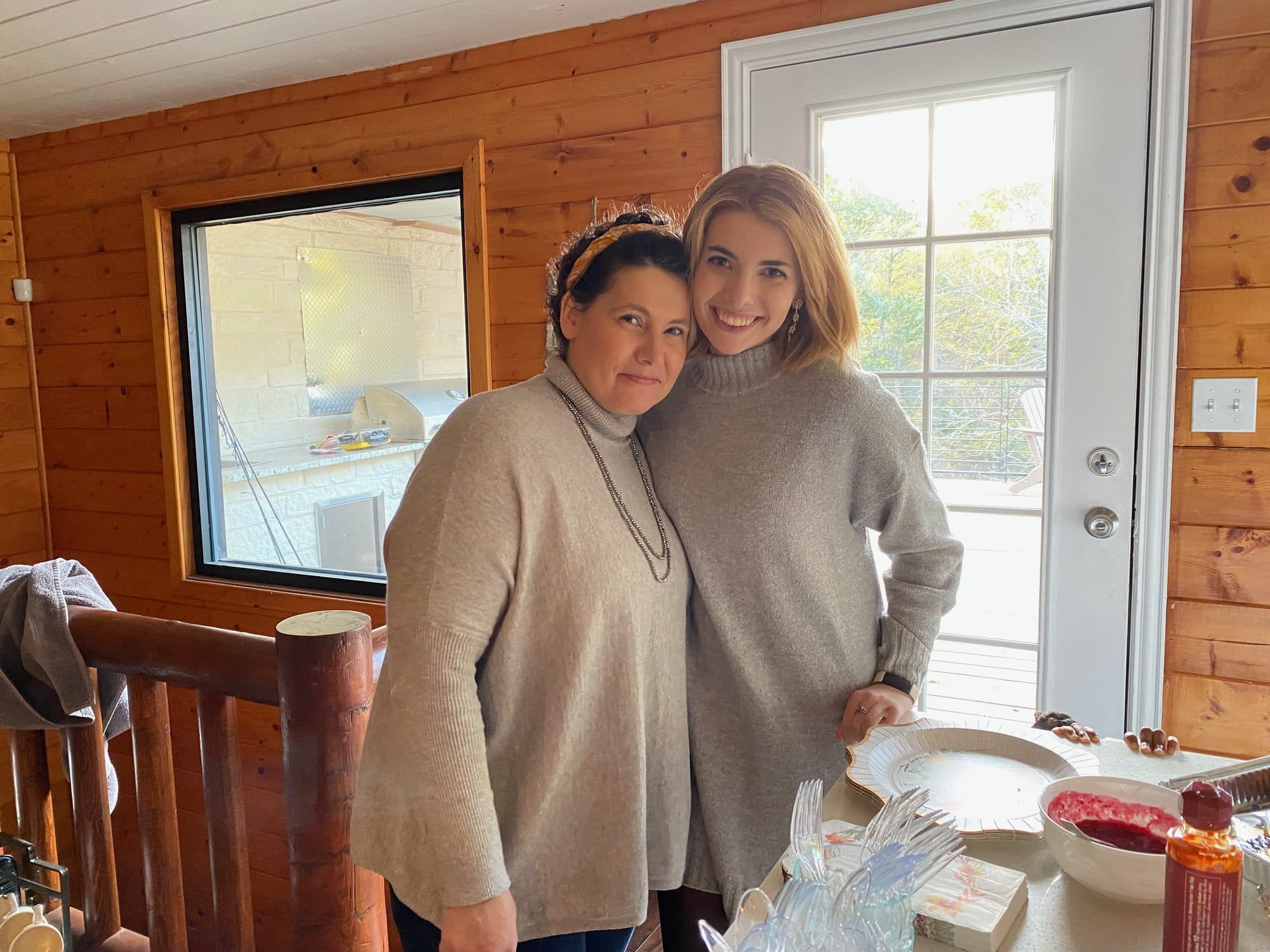 Mother and daughter posing in a wood-paneled room
