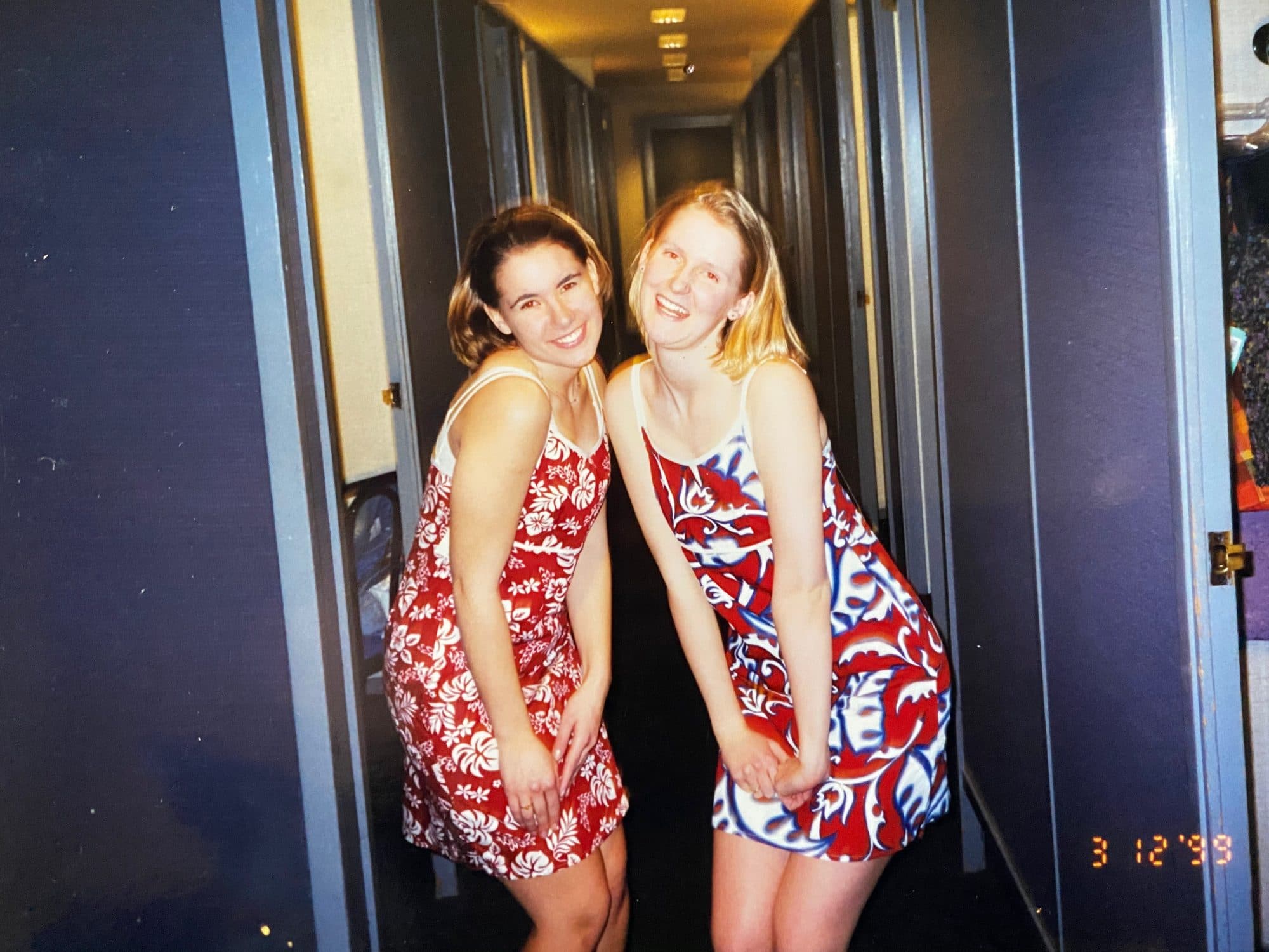 Two young women posing in matching floral dresses