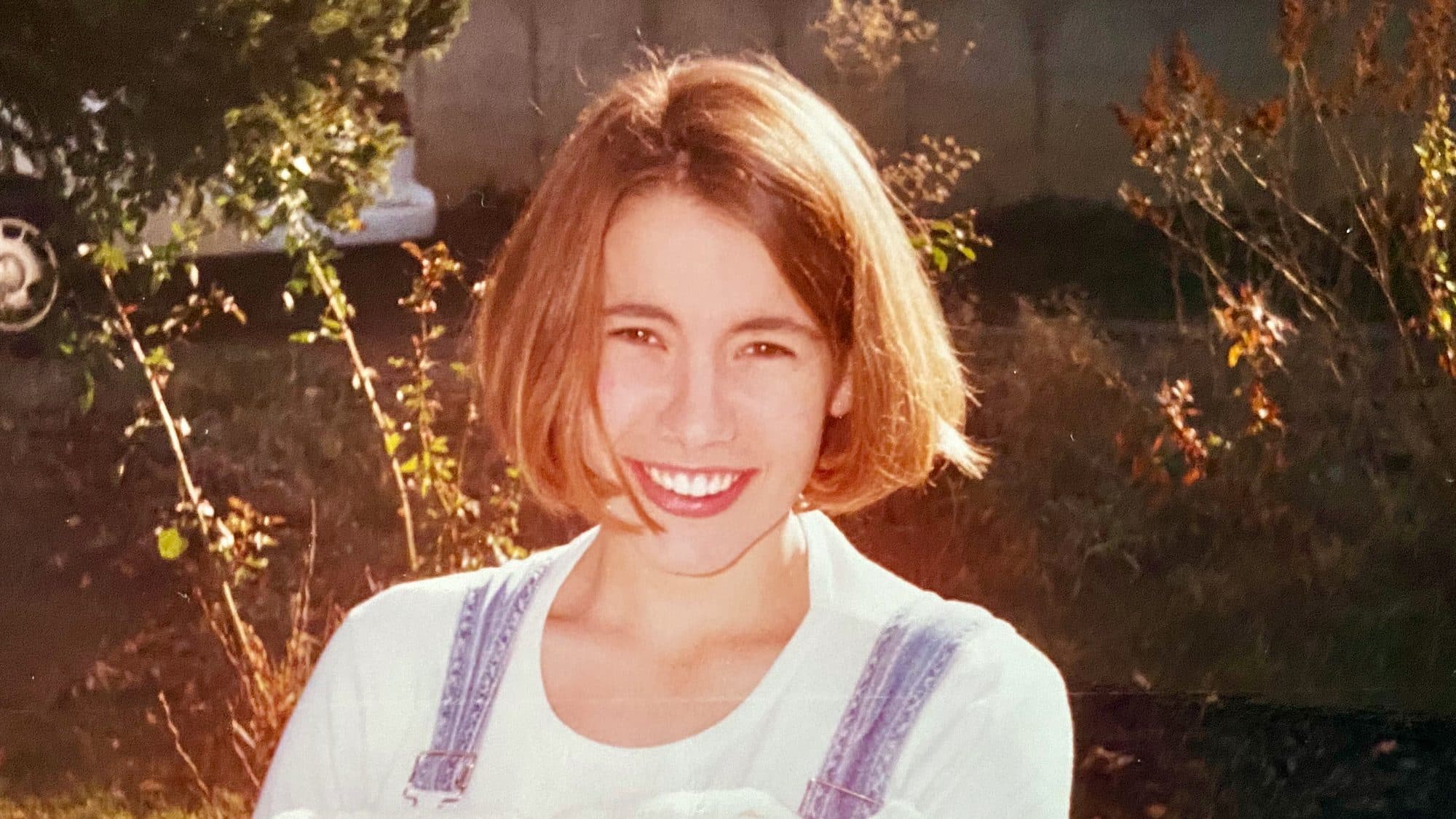 Young woman smiling outdoors in autumn light