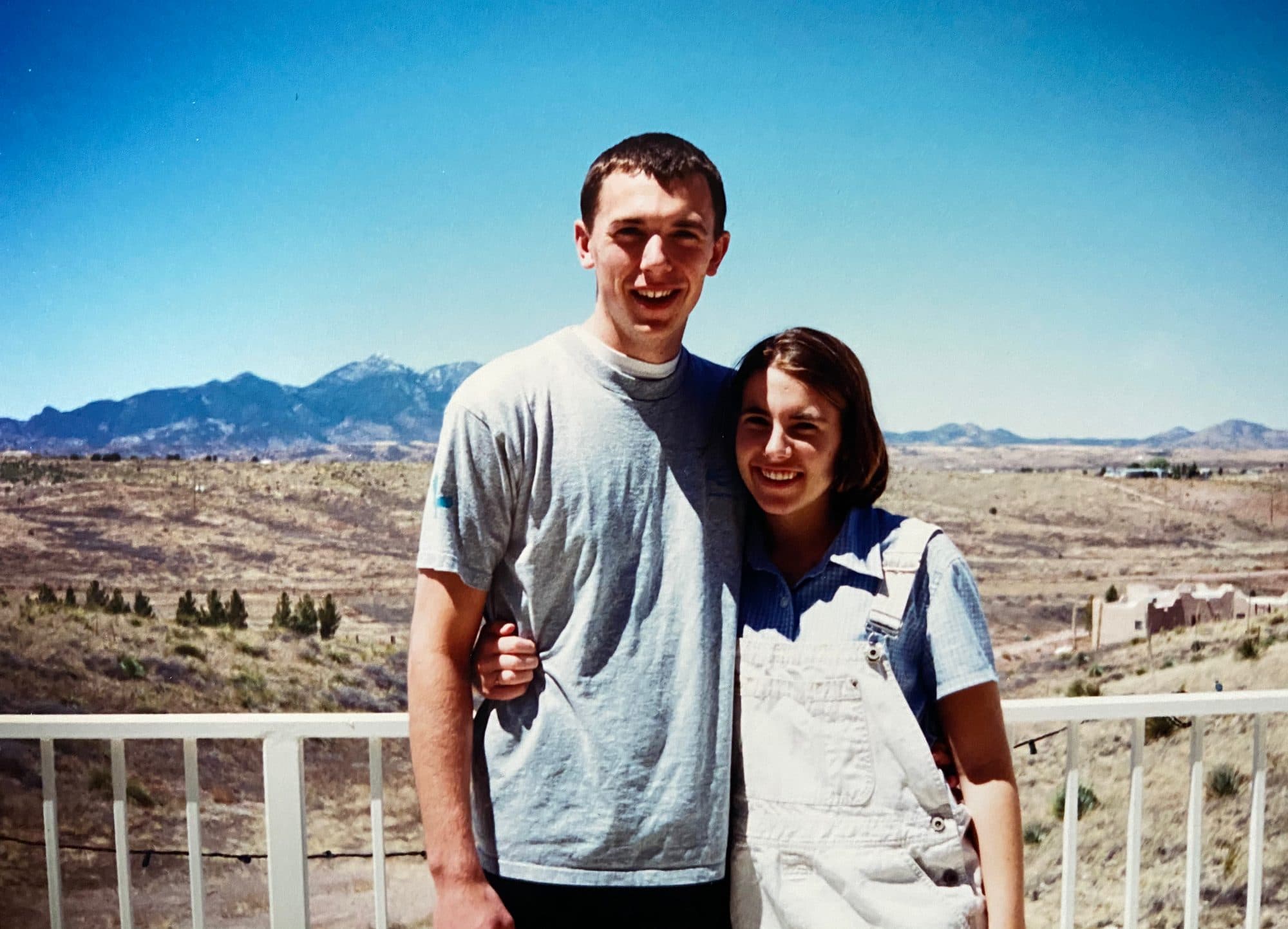 Couple posing on a deck overlooking a desert valley