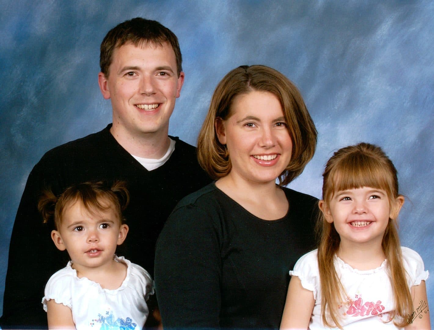 Formal studio portrait of a family of four