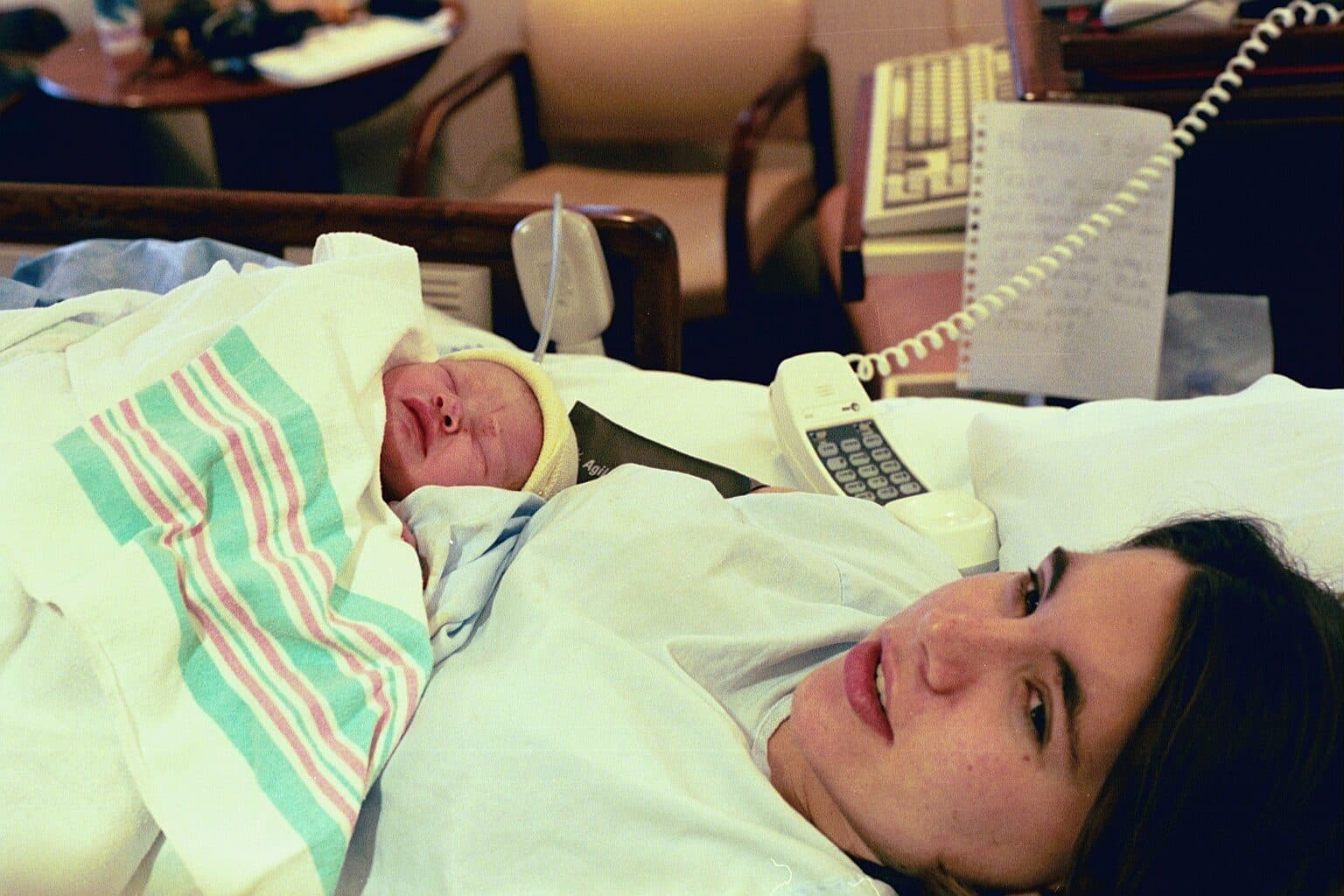 Mother lying in a hospital bed with newborn