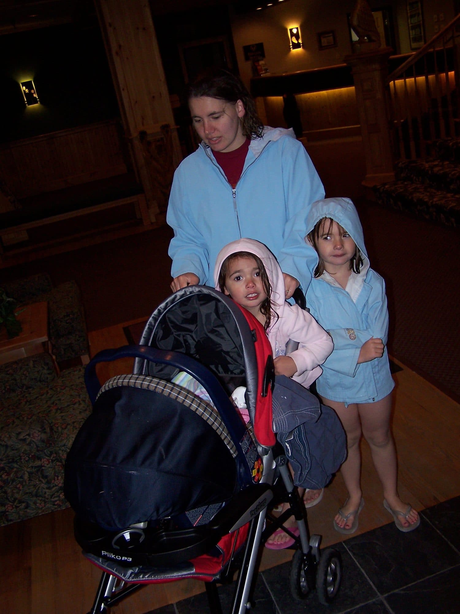 Three girls with a stroller in a hallway