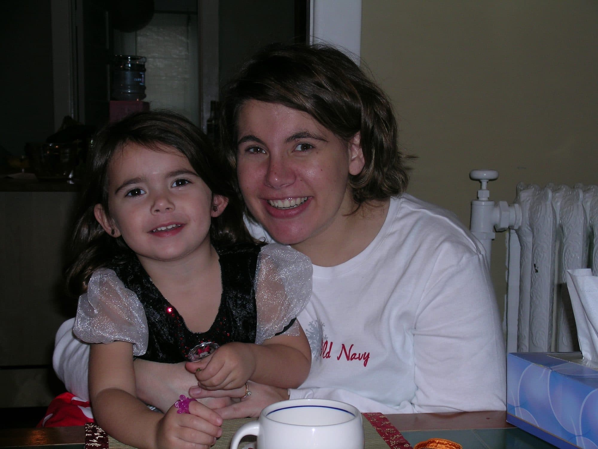 Girl in costume poses with woman at table