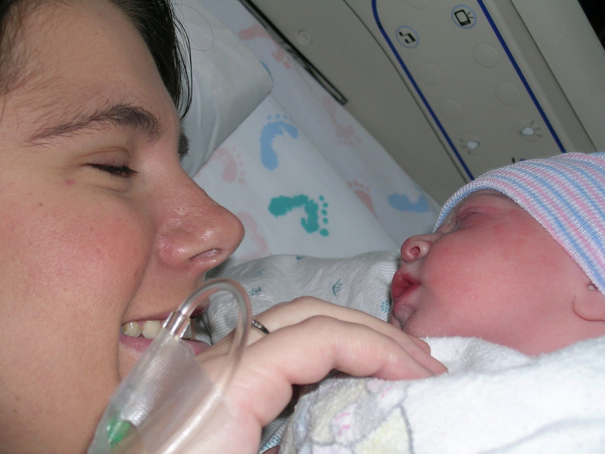 Mother smiles close to her newborn