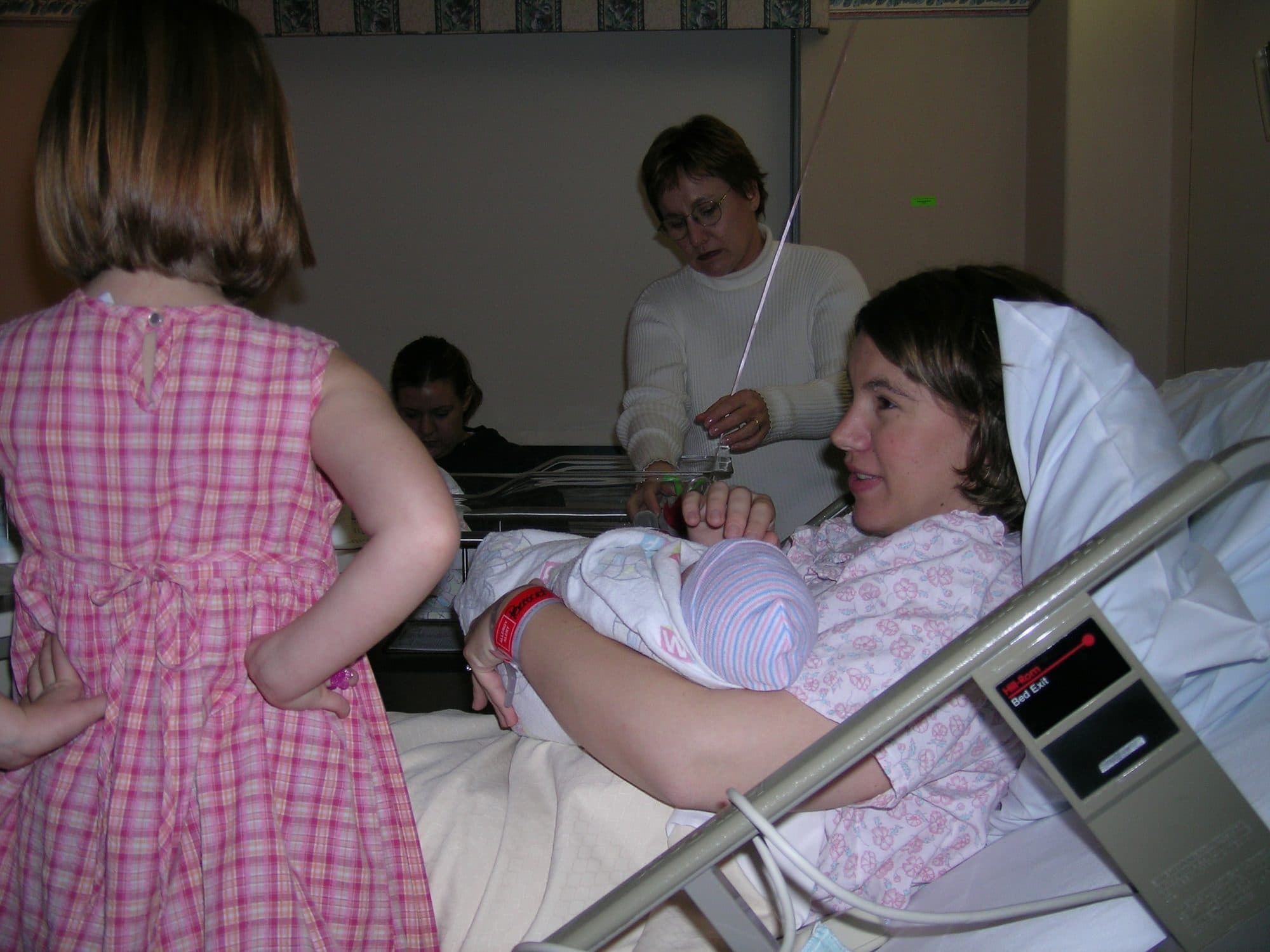 Woman with newborn and daughter in hospital
