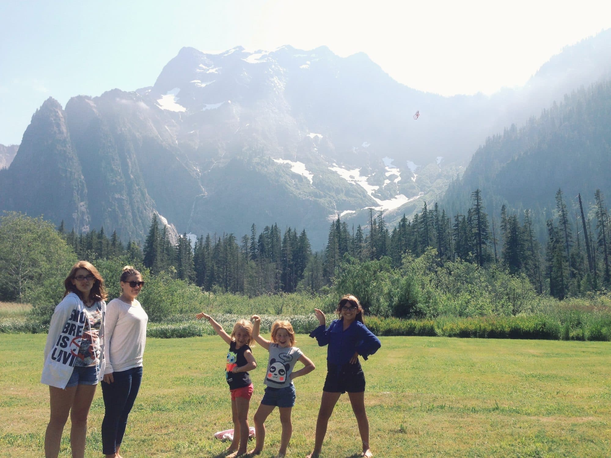 Family poses before snow-capped mountains