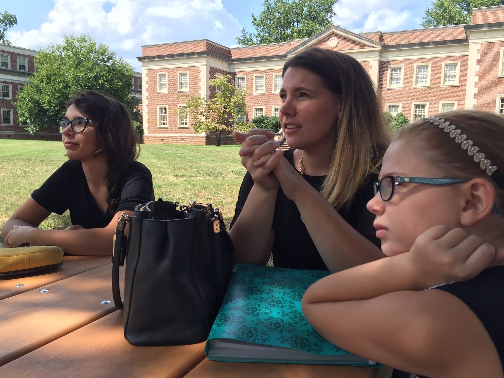 Two women and a girl at an outdoor picnic table