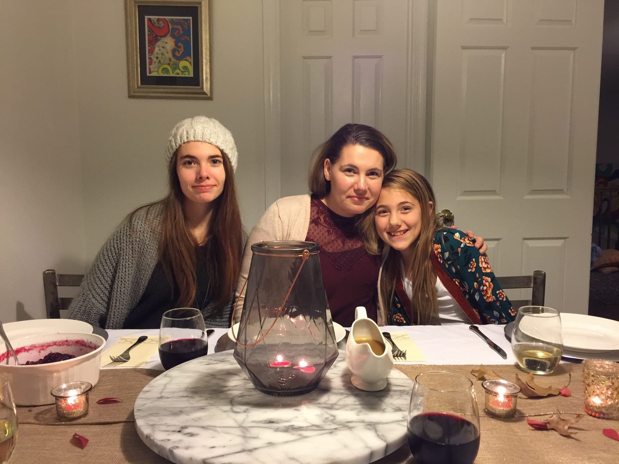 Woman and two girls at a candlelit holiday dinner