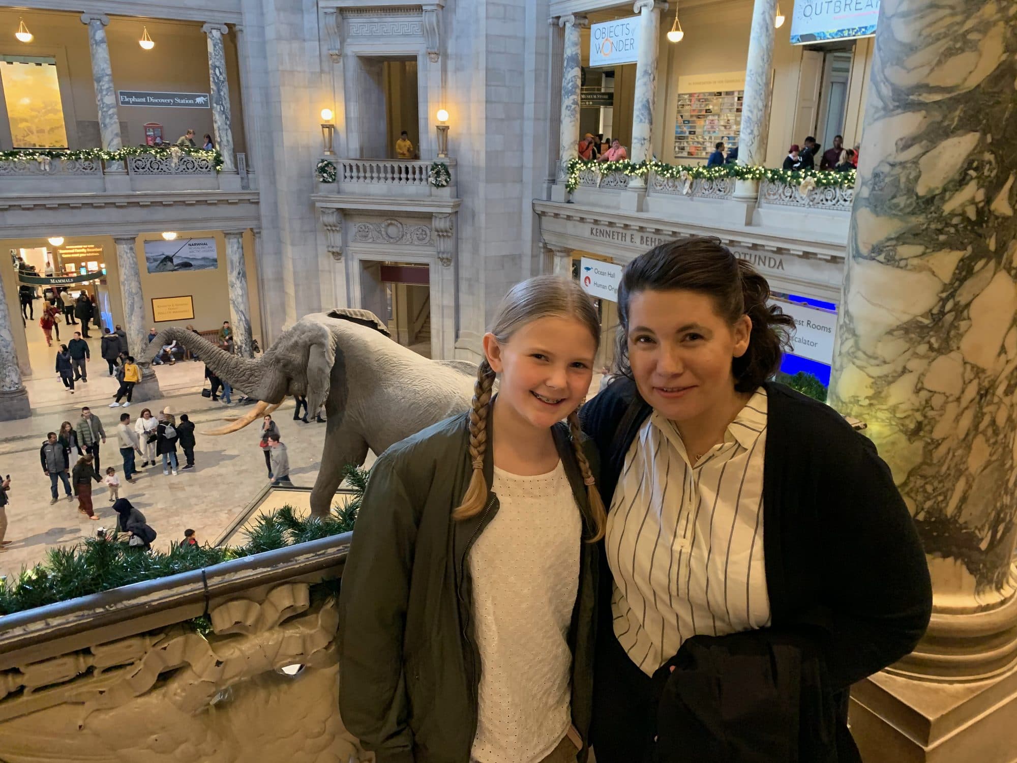 Woman and girl pose inside a grand museum hall