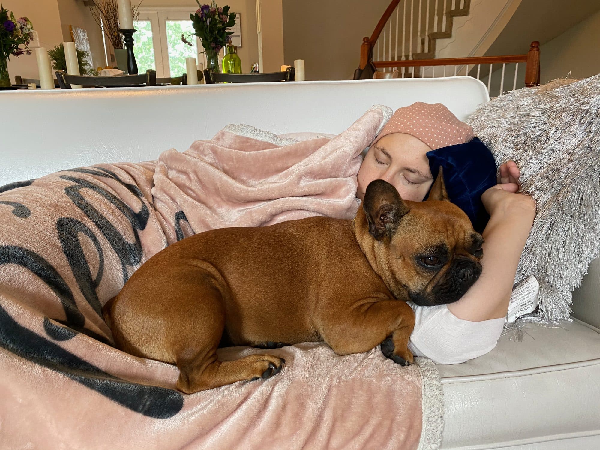Woman rests on the couch with her dog