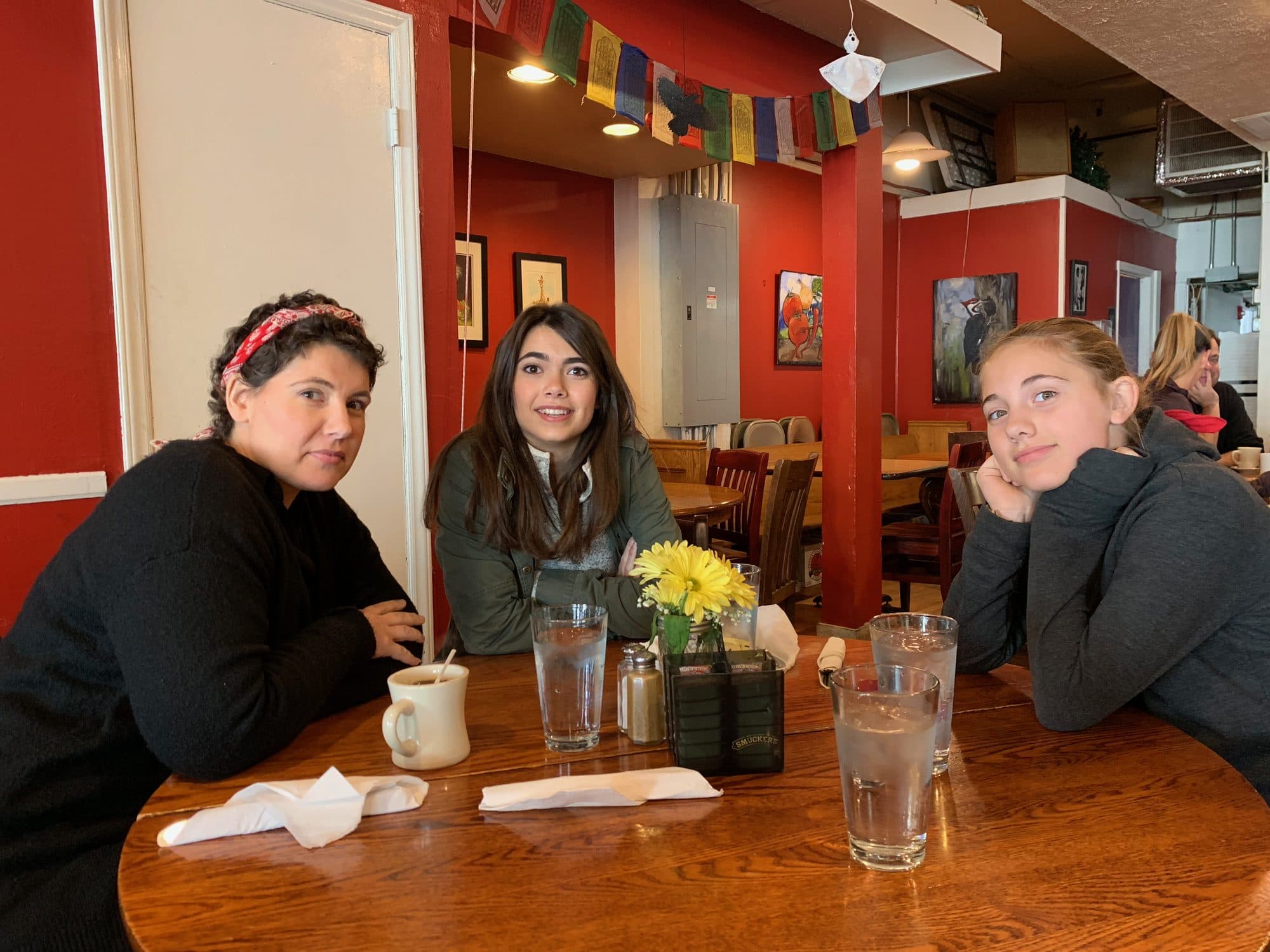 Three women seated at a colorful restaurant table