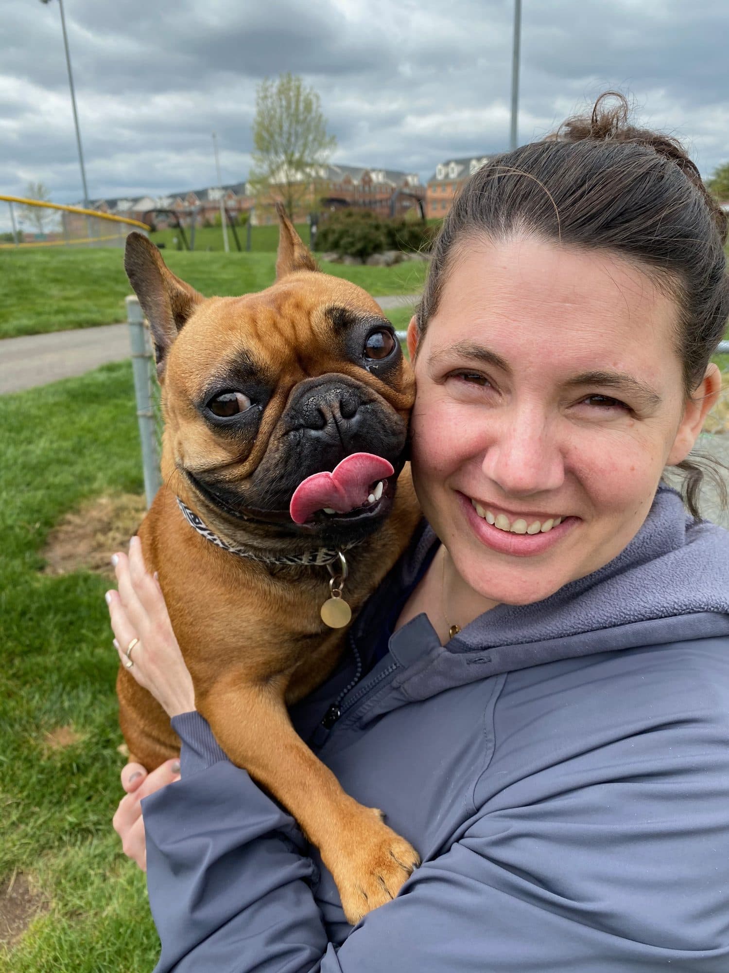 Woman holding a small dog outdoors