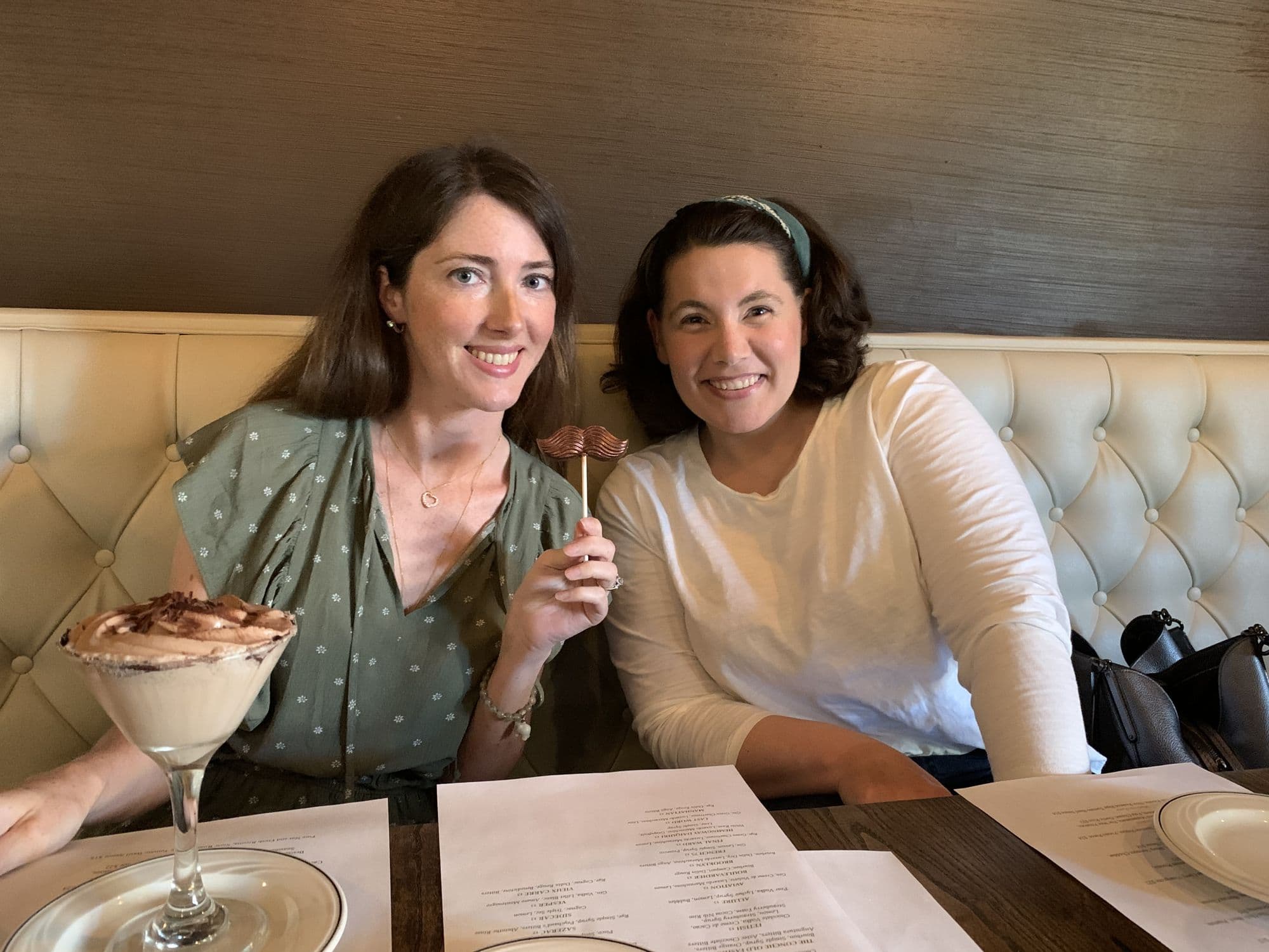 Two women share dessert at a restaurant booth