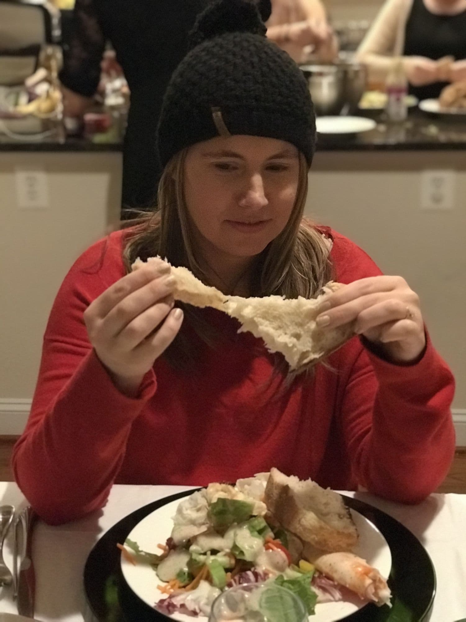 Woman in beanie eating bread