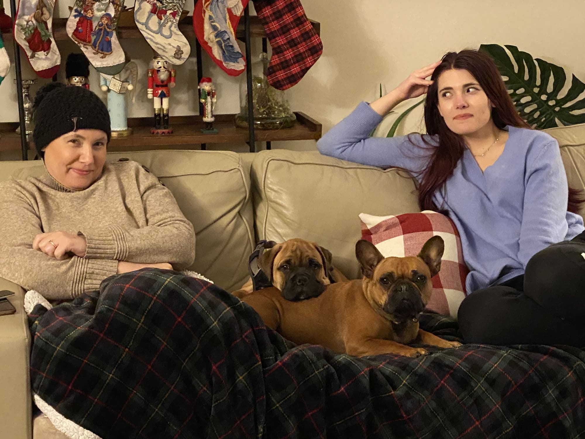 Woman and dogs rest on the couch at Christmas
