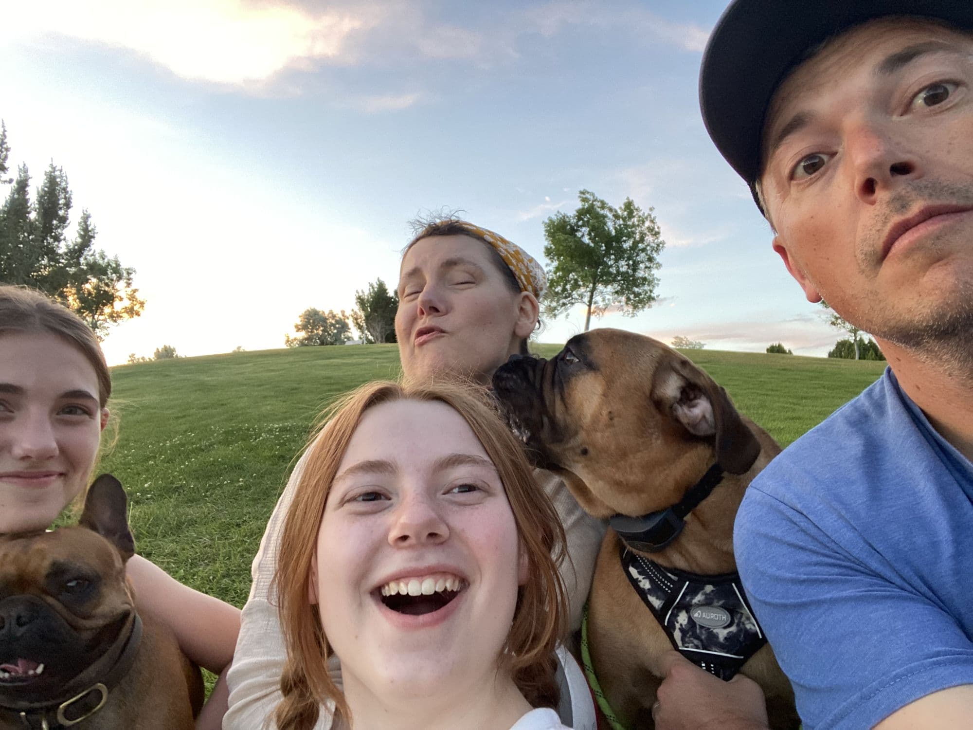 Four family members and a dog on a hillside