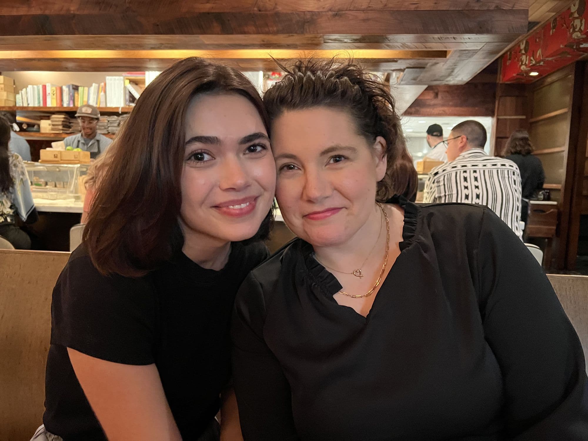 Two women close together at a restaurant