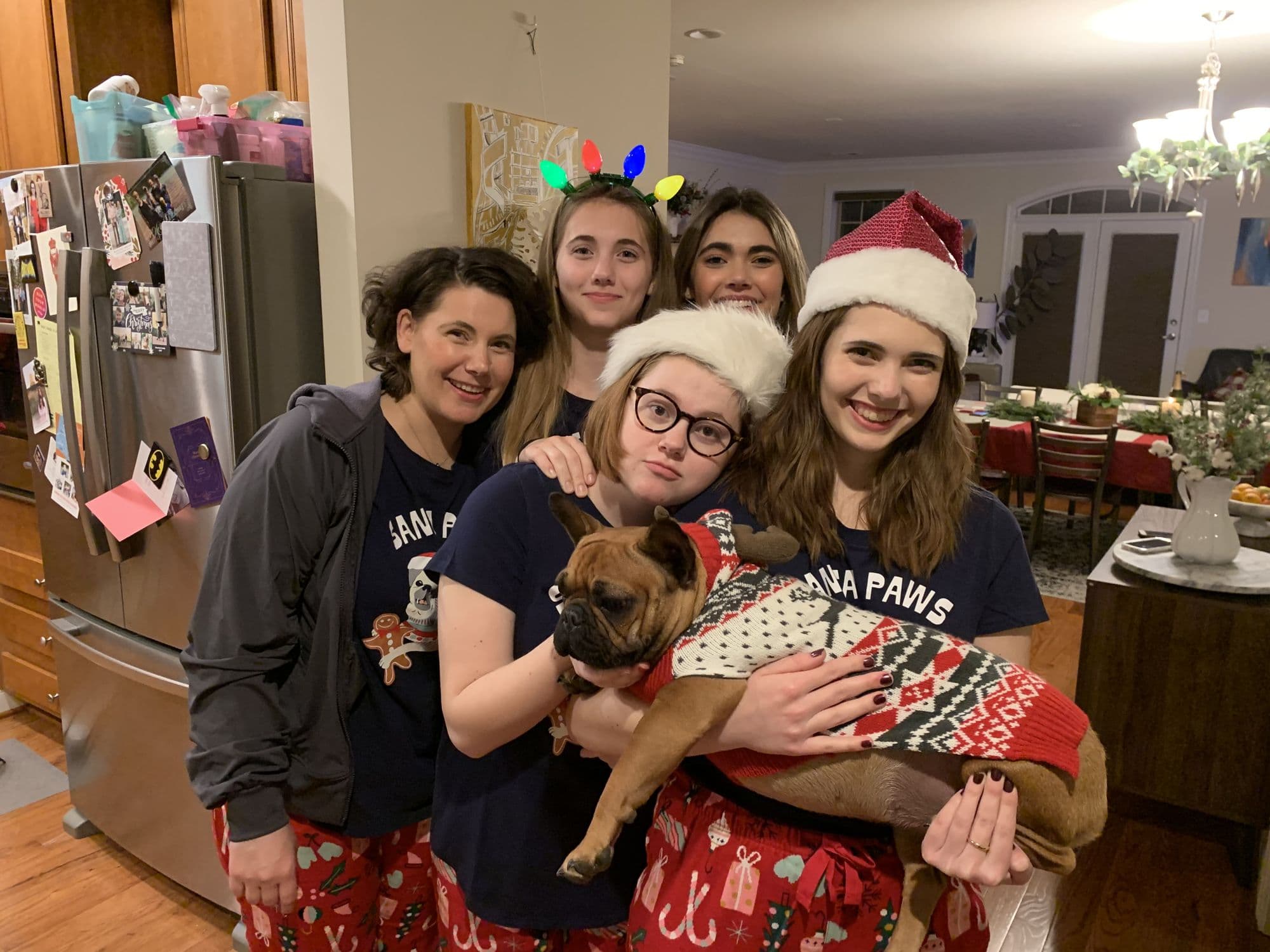 Family in pajamas with a small dog at Christmas