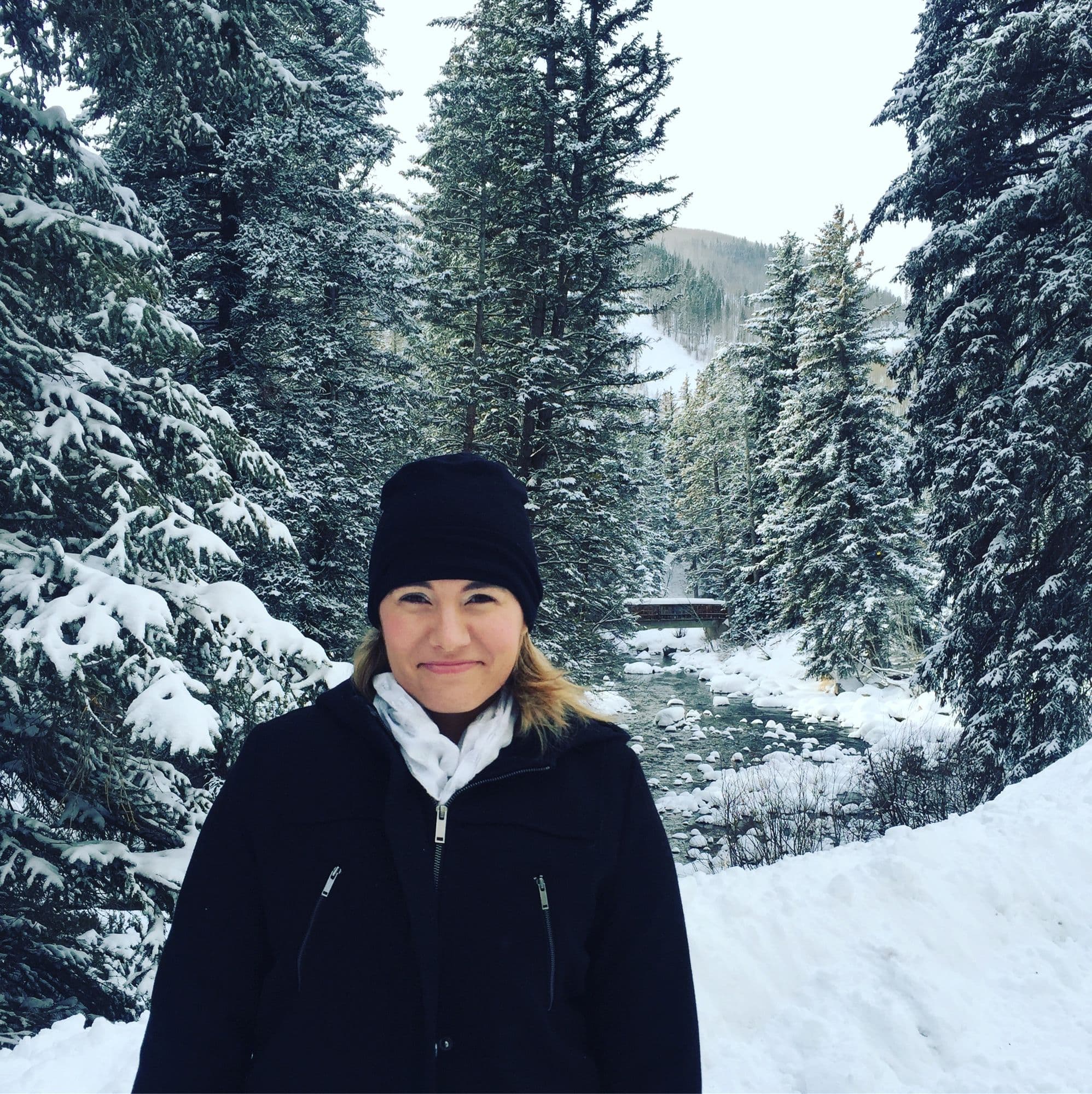 Woman standing on a snowy forest path