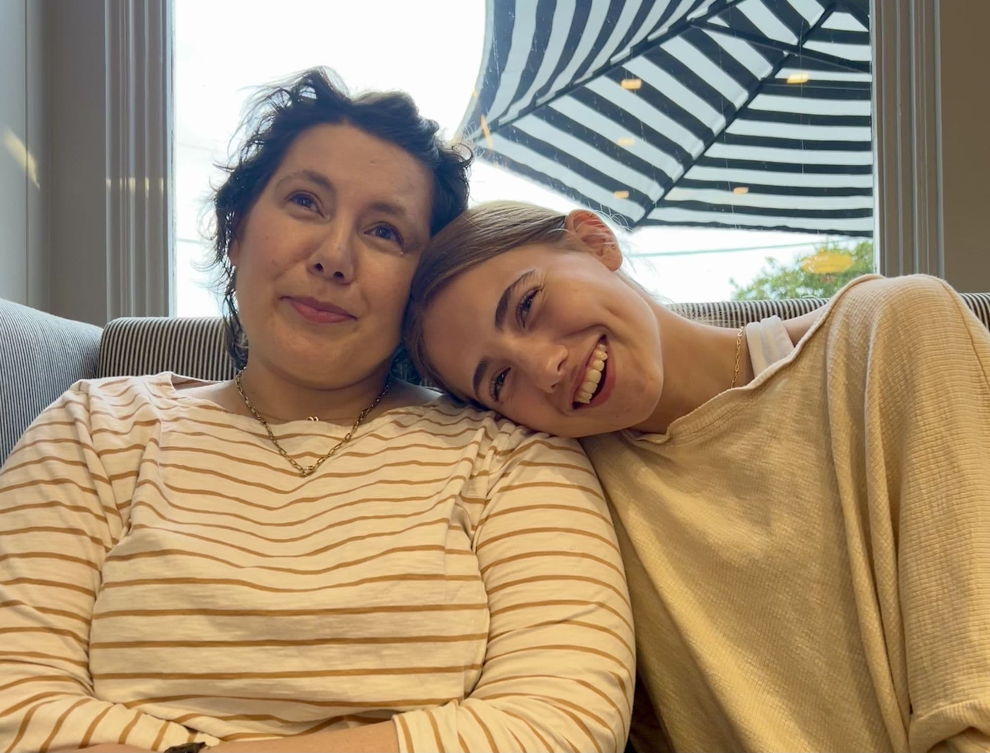 Two women resting together on a couch