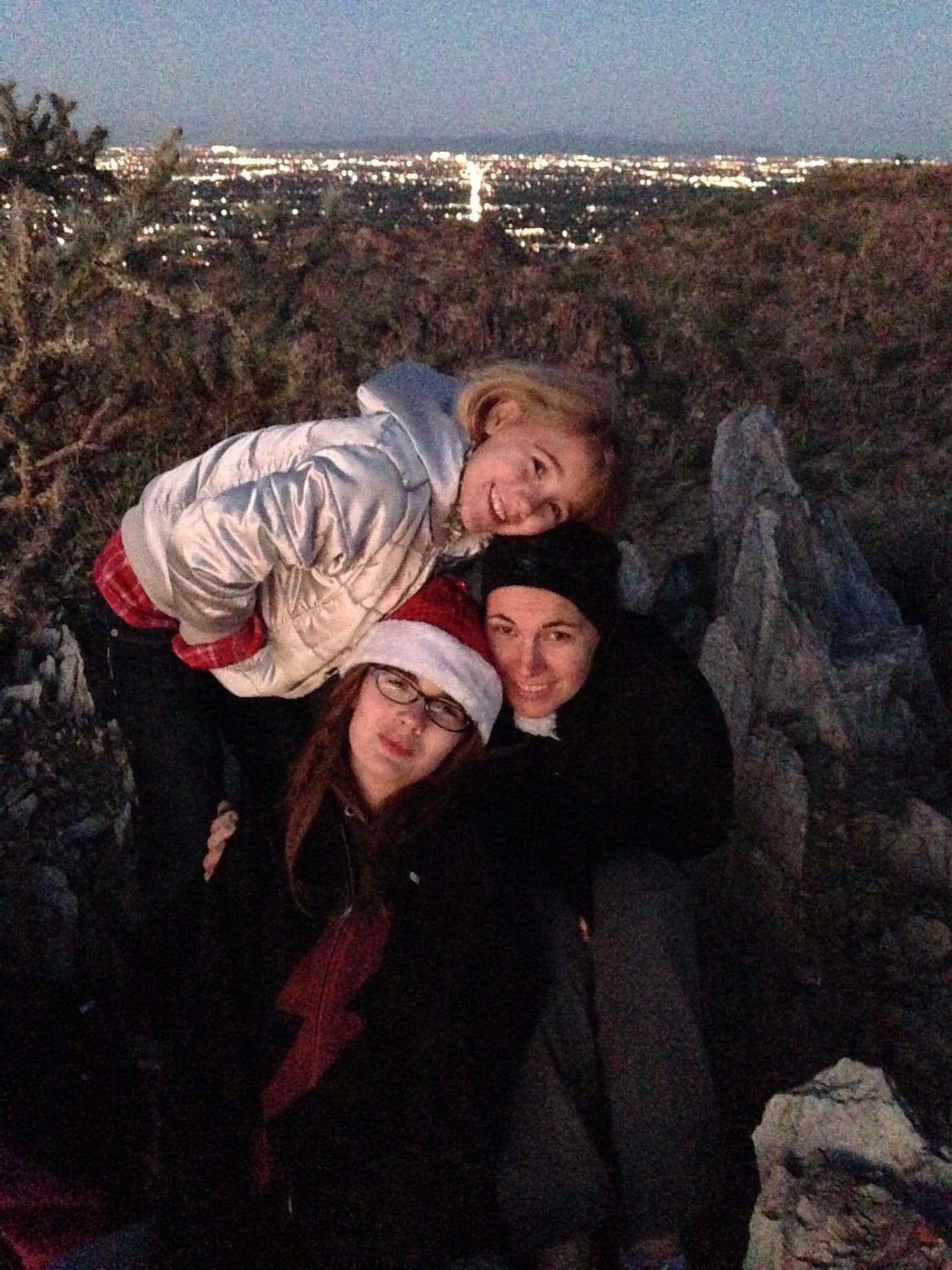 Three people close together on a hillside