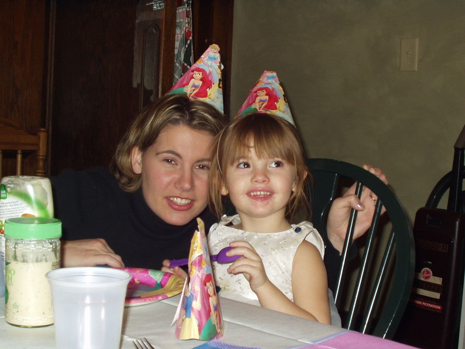 Woman and girl wear princess hats at a party